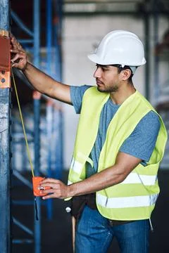 Leave no room for error. a young builder using a measuring tape at a Stock Photos