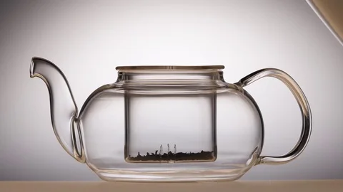 Leaves of green tea are brewed in teapot, white background Vidéo 73769002