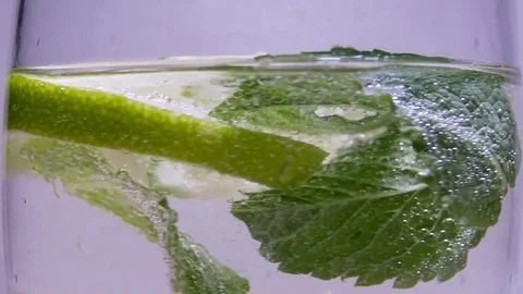 Leaves of Mint and Slices of Lime In Pouring Soda Stock Footage