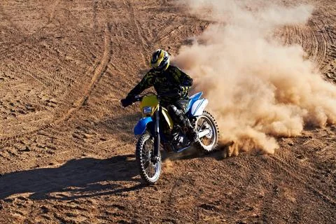 Leaving his competitors in the dust. A dirt biker riding along a track with a Stock Photos