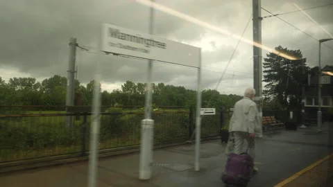 Leaving Manningtree by train. Old people walking down platform. UK. Stock Footage 214298951