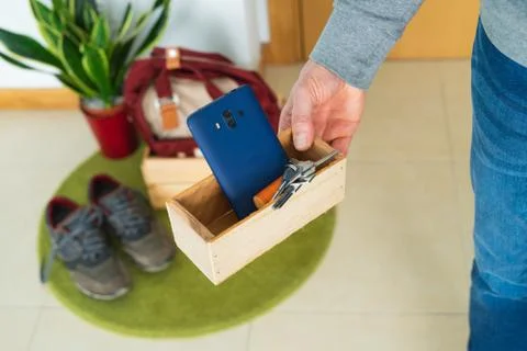 Leaving things when you get home, keys and cell phone in a wooden box. COVID- Stock Photos