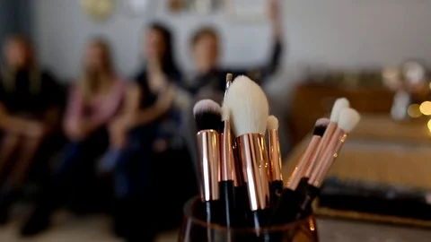Lecture at make-up workshops, make-up brushes in the foreground Stock Footage 121040697
