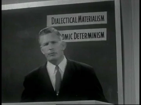A lecturer in 1955 explains how atheism shapes communism, illustrating his Stock Footage 75274506