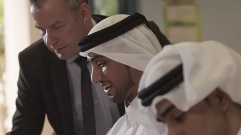 Lecturer assisting Qatari men in classroom. Stock Footage 90816363