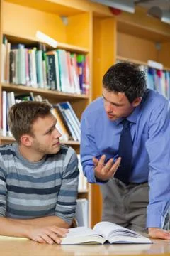 Lecturer explaining something to focused student Stock Photos