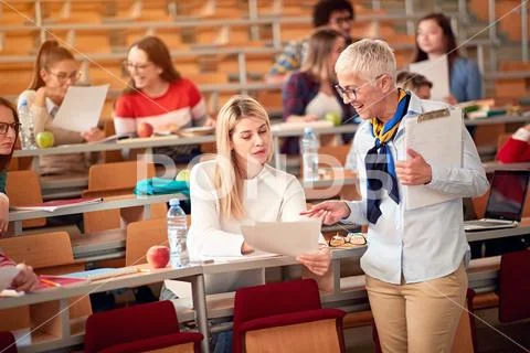 Lecturer with girl student in an exam in a classroom. Stock Photos