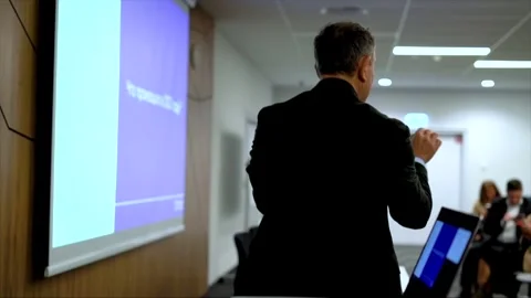 Lecturer speaking into microphone from behind during presentation Stock Footage 335653003