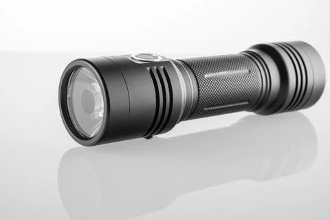 LED black flashlight close-up on white background, trace of bright light Stock Photos