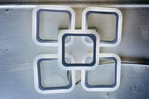 LED chandelier with interlinked square frames, white and gray color scheme,.. Stock Photos