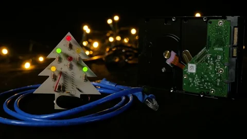 LED christmas tree with hard drive in background and ethernet cable around it. Video stock 81674598