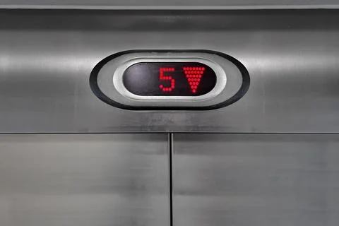 LED Display Above Elevator Stainless Steel Door Showing Floor Number 5 Stock Photos