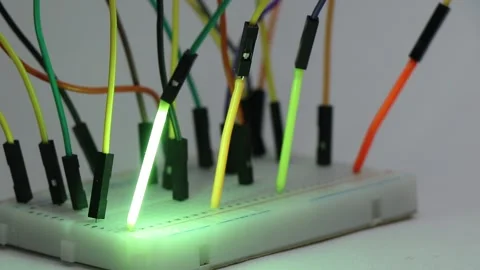 LED filament tubes lighting up in order on a breadboard circuit Stock Footage 336626339