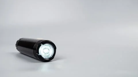 Led flashlight on gray background with copy space Stock Photos