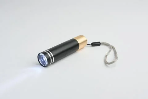 LED Flashlight Turned On Against White Background Stock Photos