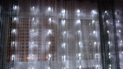 LED garlands flash behind the flat window glass. soft variable focus 動画素材 100371744