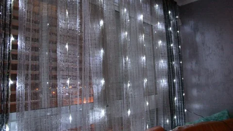 LED garlands flash behind the flat window glass. soft variable focus 動画素材 100371745