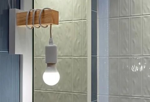 LED lamp with coiled cable in the interior of the bathroom. Stock Photos