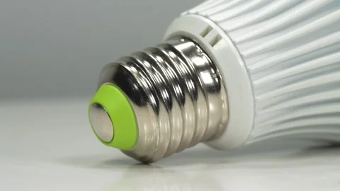 LED lamp with E27 base on grey background, close-up shot video Stock Footage 342142467