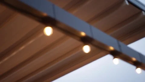 LED lantern bulb string lights with black wire attached to beam construction Stock-Footage 72603116