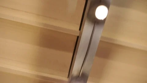 LED lantern bulb string lights with black wire attached to cream colored ceiling Stock Footage 72603207