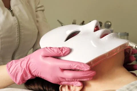LED light anti-aging mask for facial skin care in a spa slow motion. A woma.. Stock Photos