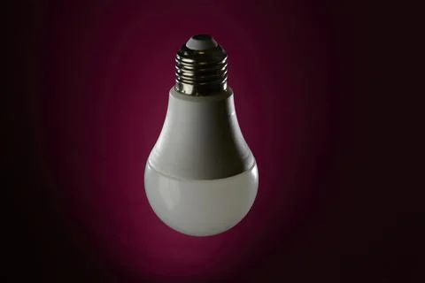 LED light bulb floating on dark magenta background with vignette lighting Foto stock