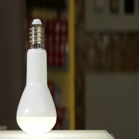 LED light bulb is glowing on the bench in the shop. Moving the camera. Close-up Stock Footage 69429872