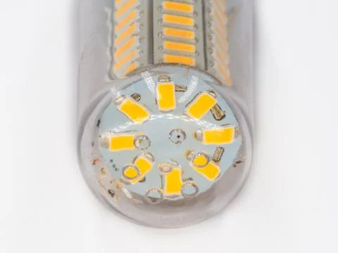 Led light yellow diodes inside plastic transparent cover closeup on white. Stock Photos