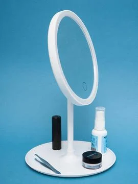 Led mirror with skincare tools styled scene Stock Photos