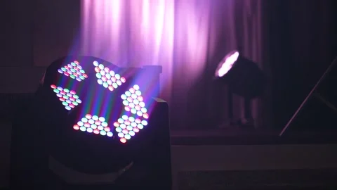 LED moving head stage light emitting pink and purple beams in smoke Stock Footage 346356965