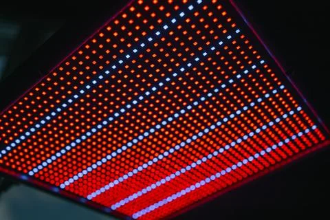 Led panel glowing with intertwining red and blue light patterns, illuminating Stock Photos