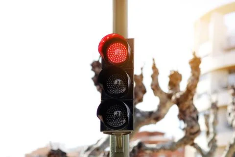 LED red light traffic light on defocused european buildings and trees backg.. Stock Photos