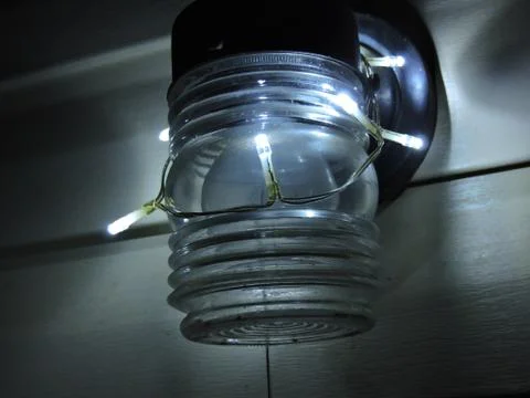 Led string lights wrapped around a front porch light Stock Photos