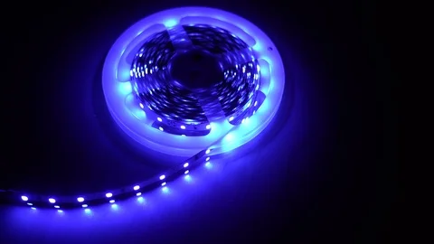 Led strip coil closeup. Diode shining stripe on dark blue background. Stock Footage 113010112