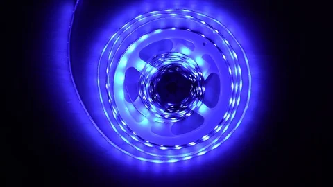 Led strip coil closeup. Diode shining stripe on dark blue background. Stock Footage 113011313