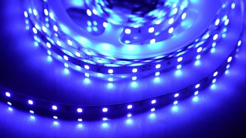 Led strip coil closeup. Diode shining stripe on dark blue background. Stock Footage 113011323
