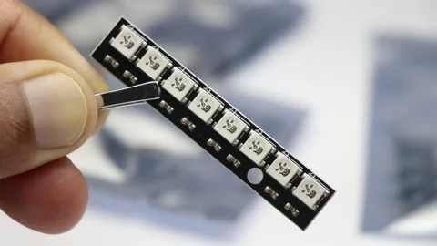 Led strip with hard mount pcb surface and argb leds held by tweezers Stock Footage 344782121