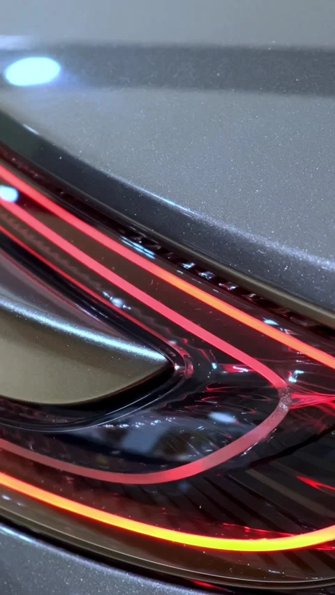 LED tail lamp cluster detail glowing on silver metallic rear bodywork. Dramatic Stock Footage 339320798