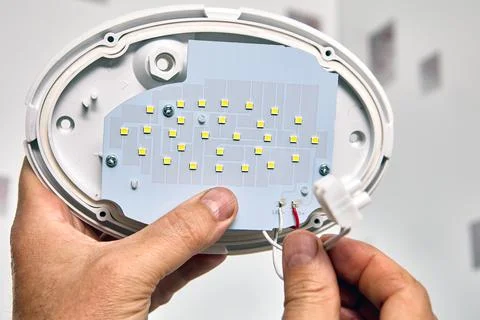 LED wall light panel, electrician connect wires. Foto stock