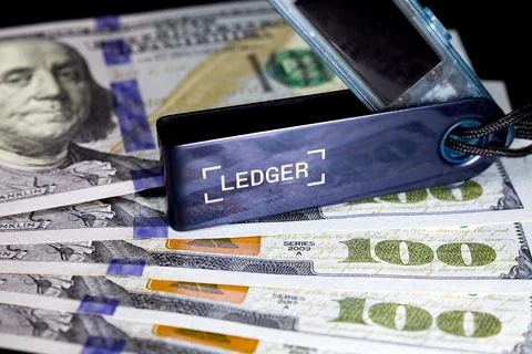 Ledger hardware wallet on stack of us dollar bills with benjamin frank Stock Photos