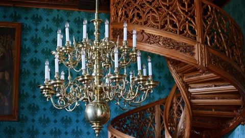 Lednice, Czech Republic - July 19, 2026: A brass chandelier with white candles Stock Footage 342296236