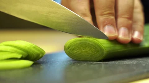Leek cutting process. A man holds a vegetable in his hands Stock Footage 135837541