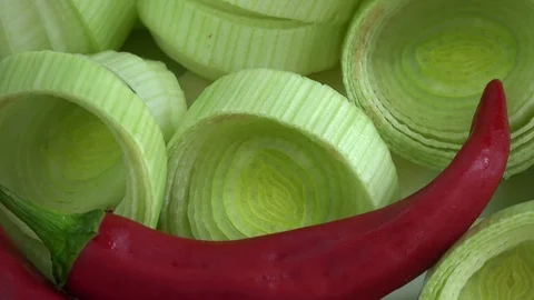 Leek slice and red hot chili peppers rotating background Stock Footage 95269433
