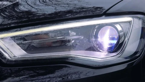The left car headlight goes on - closeup Stock-Footage 77300534