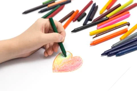 Left hand drawing a heart shape with colored crayons pastels Stock Photos