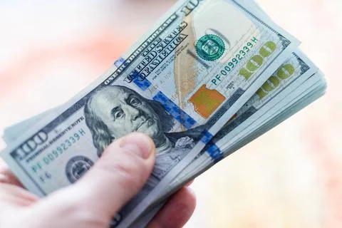 Left hand holding stack of us dollar banknotes Stock Photos