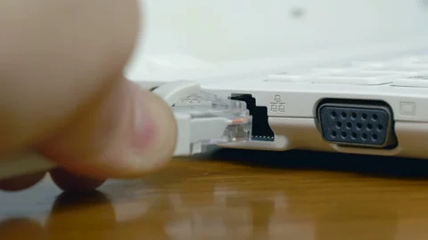 Left hand inserting a network cable into a laptop Stock Footage 87378902