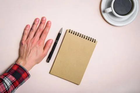 Left hand near note pad and coffee Stock Photos