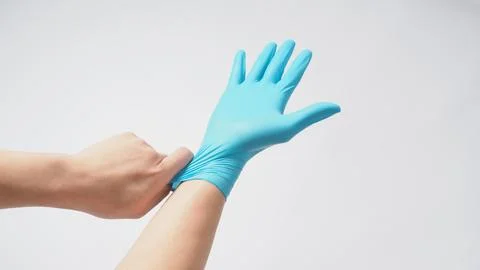 Left hand is pulling right hand with blue latex gloves on white background. Stock Photos